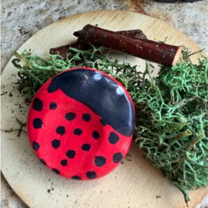 polymer clay worry stone painted to look like a ladybug