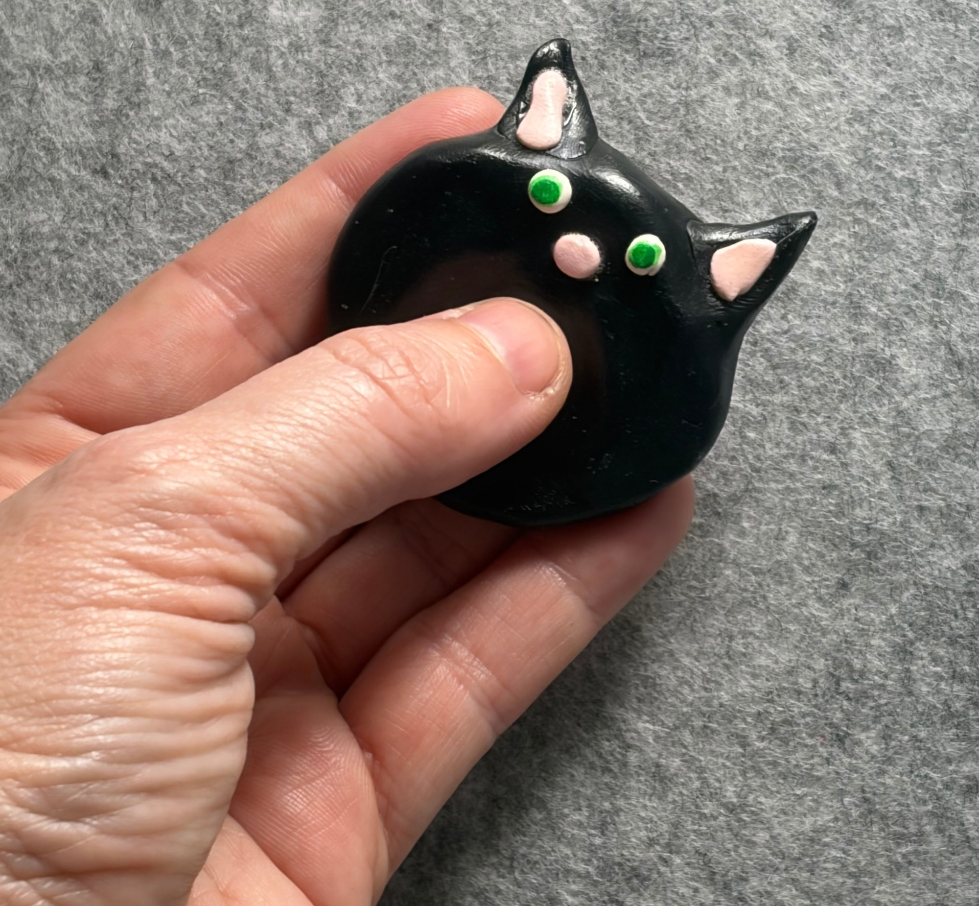 black cat worry stone 2 Black cat worry stone held in hand for scale